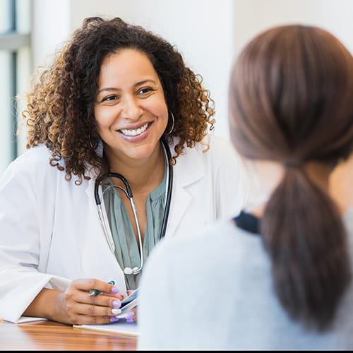 A smiling doctor talking to a patient.