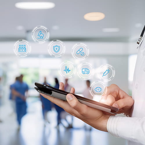 Clinician holding a tablet with floating medical icons above it, including a microscope, shield, pill, heartbeat line, ambulance, syringe, and eye.