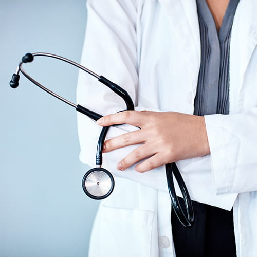 Doctor in a white coat holding a stethoscope.