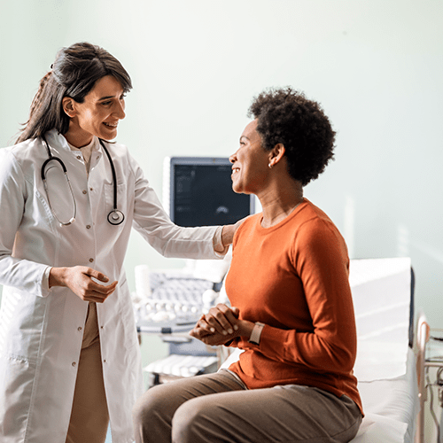 A medical practitioner reassuring a female patient.