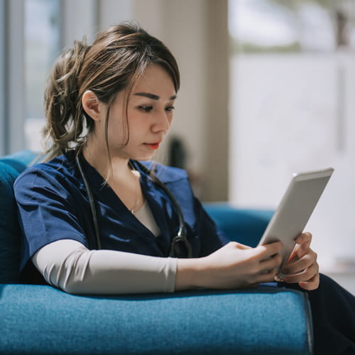 A medical student reads from a tablet.