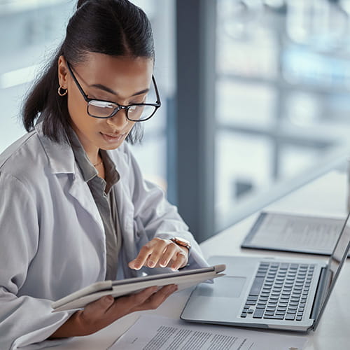 Medical student reading an electronic tablet at her desk