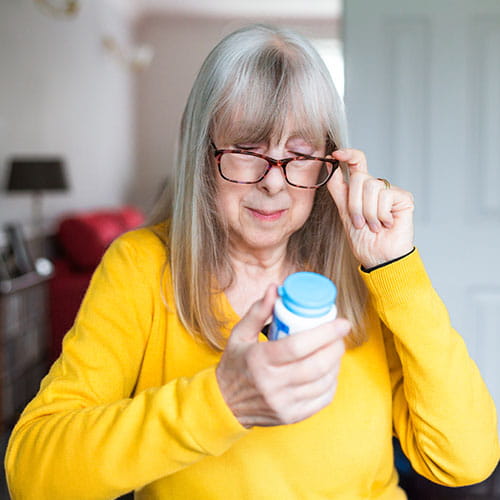 woman holding aspirin bottle