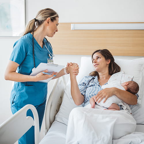 nurse holding a new moms hand
