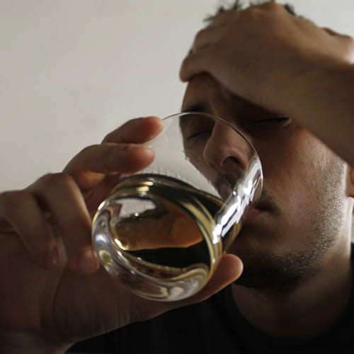 Man drinking glass of hard liquor