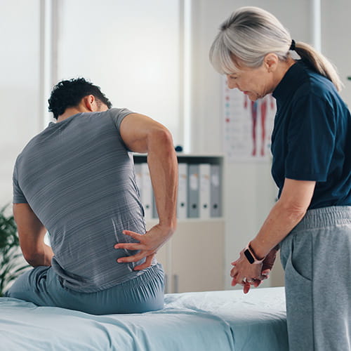 Medical professional examining a patients back