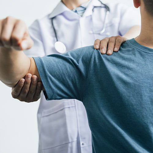 doctor examining a mans shoulder