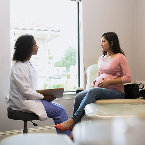pregnant woman talking to doctor