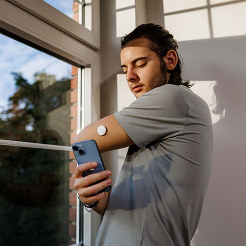 man checking his diabetic technology