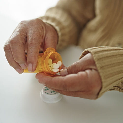 person holding bottle of pills
