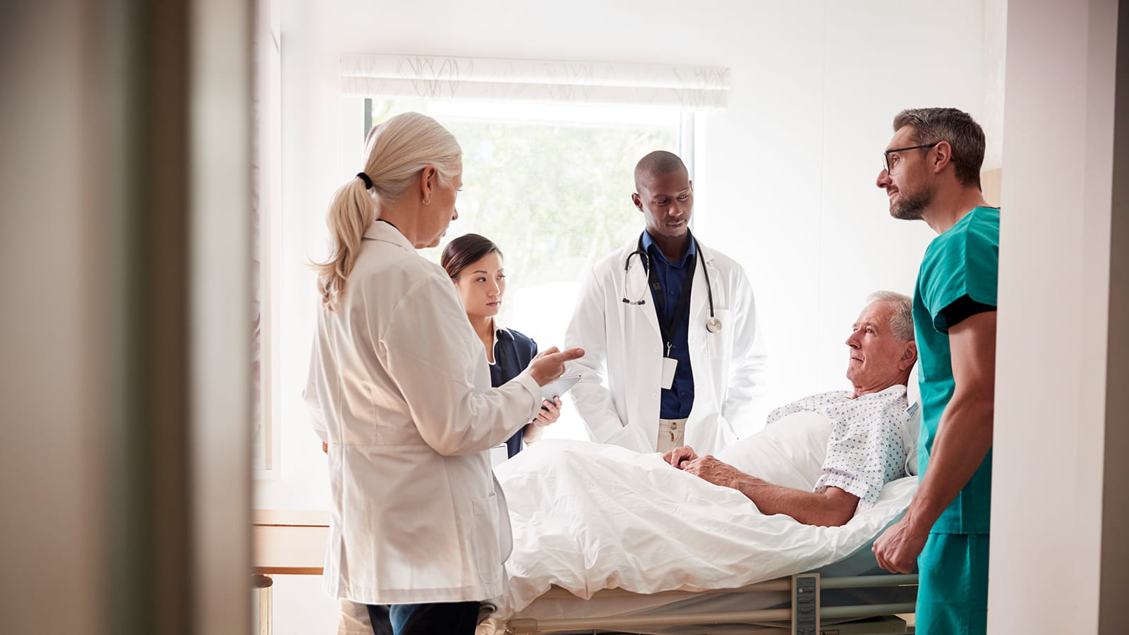 doctors talking to patient in bed