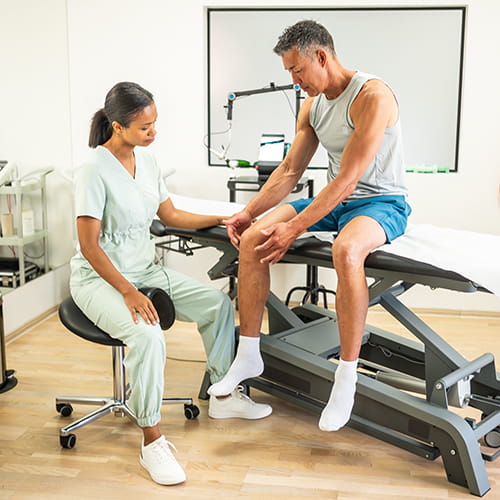 doctor examining patients knee