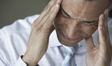 middle aged office worker with visible tension headache