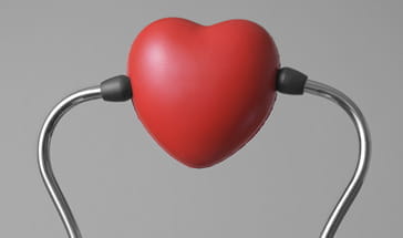 rubber heart placed between two ear sockets of a stethescope